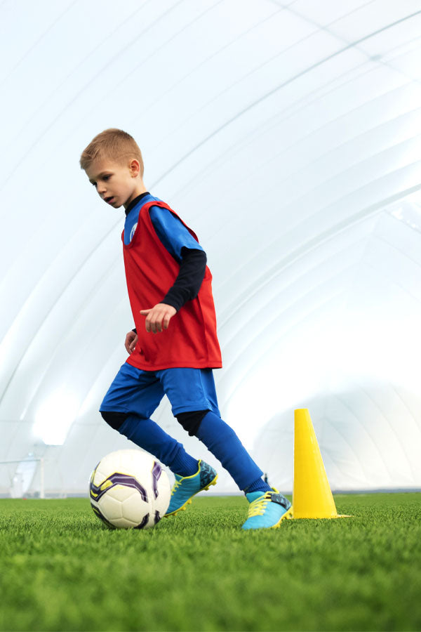 Children playing on soft artificial grass in backyard play area – child-safe turf by PlantsWorld.ae